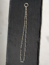 Load image into Gallery viewer, Silver chain with a clasp on a black slate surface
